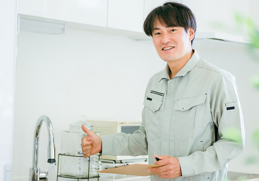 キッチン前で笑顔を見せる作業員の男性