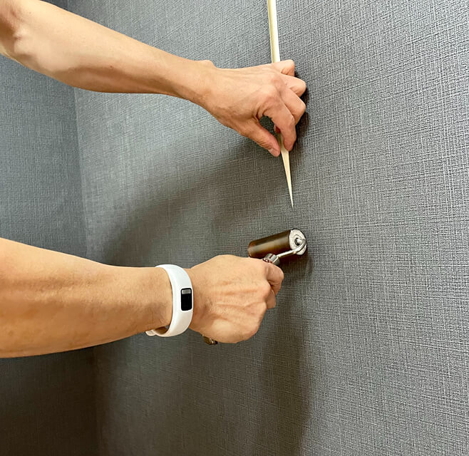壁紙を丁寧に施工する職人の手元